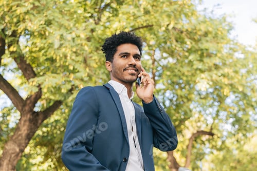 Preview: Ethnic man speaking on mobile phone