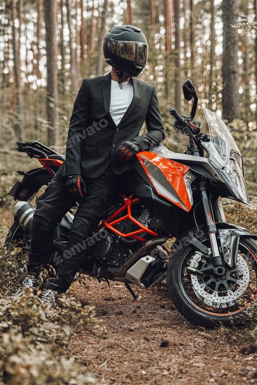 Preview: Man weared in black suit with dark motorcycle in forest