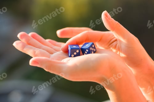 Preview: Dice 1 1 in the female hand, sunset background. Gambling devices