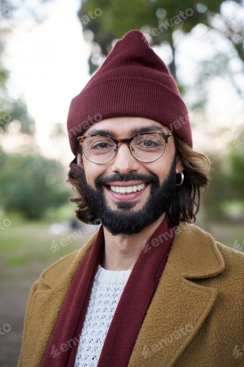 Preview: Vertical Portrait of smiling young Caucasian man with winter hat looking camera positive expression