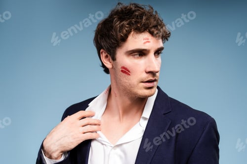 Preview: Embarrassed businessman looking away with lipstick on face