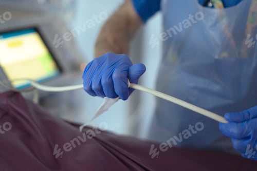 Preview: Doctor wearing blue sterile gloves preparing medical equipment in hospital room