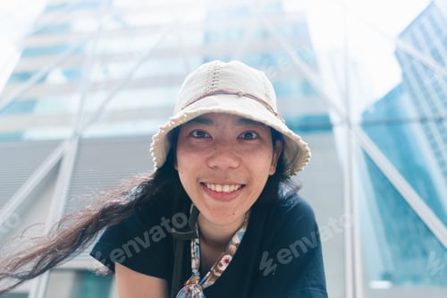 Preview: Beautiful young tourists smiling happily in the modern building in Hong Kong