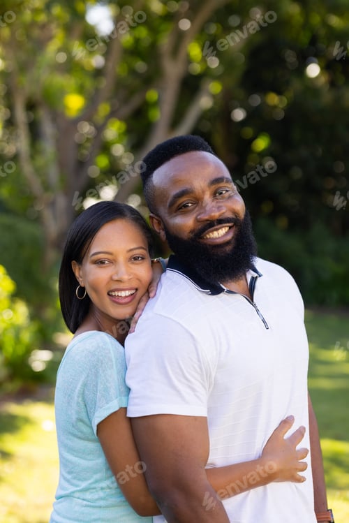 Preview: Smiling couple embracing outdoors, enjoying quality time together in park