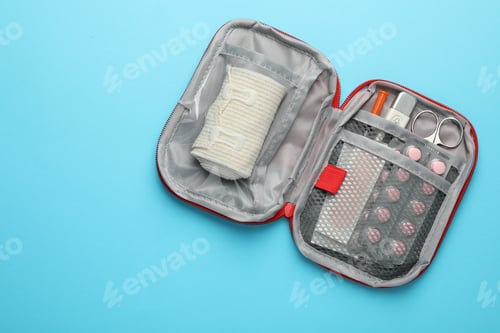 Preview: First aid kit on light blue background, top view. Space for text