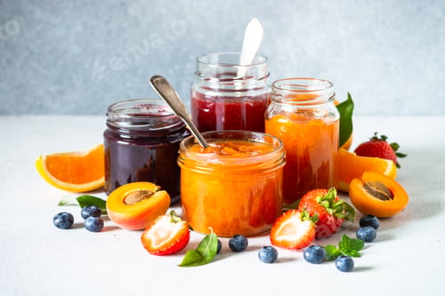 Preview: Homemade jam in glass jars at white table.