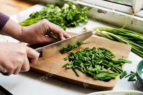 Preview: Closeup of hands with knife cutting fresh organic vegetable