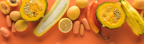 Preview: top view of yellow fruits and vegetables on orange background, panoramic shot