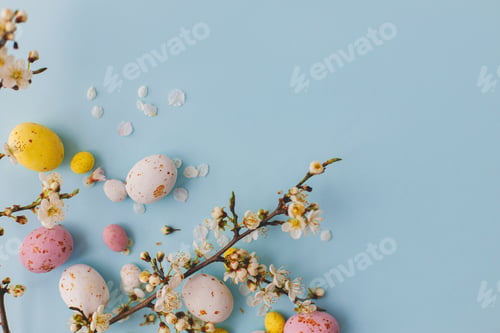 Preview: Colorful Easter chocolate eggs with cherry blossoms on blue background. Happy Easter