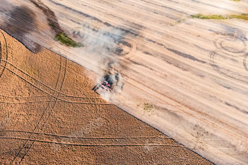 Preview: Top view of a harvester working in a field and mows wheat