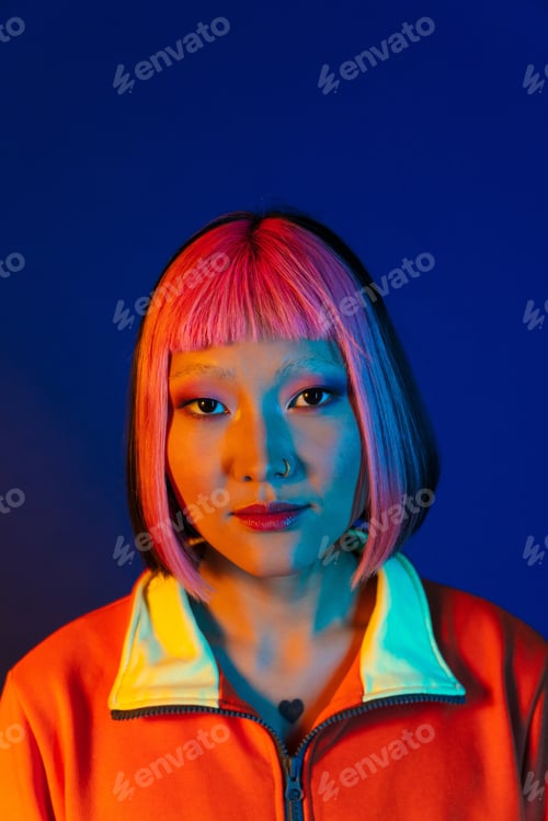 Preview: Asian girl with pink hair and piercing posing while looking at camera