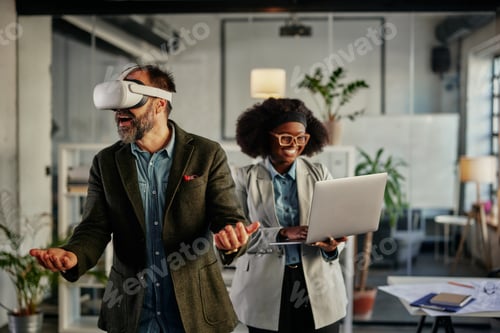 Preview: Multiracial business couple having fun with modern technology at work