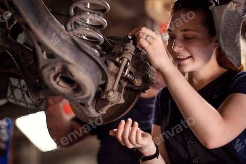 Preview: ↟ ✓ Young red-haired girl in overalls helps her father to work in an auto repair shop