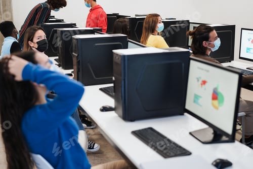 Preview: Multiracial young students using computers during coronavirus outbreak inside technology classroom