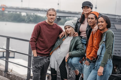 Preview: group of young friends spending time together at riverside