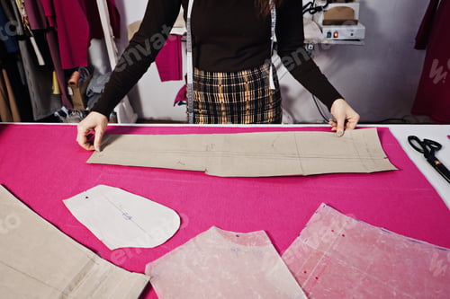 Preview: Seamstress working with sewing pattern on table in tailor shop