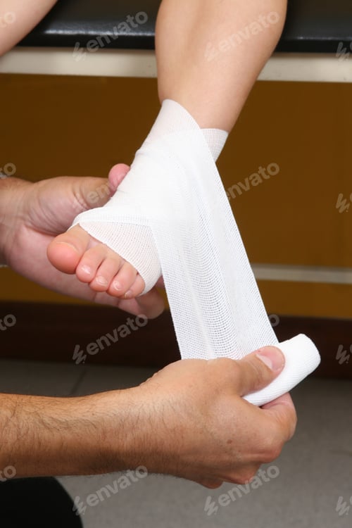 Preview: Doctor performing an ankle bandage on a girl
