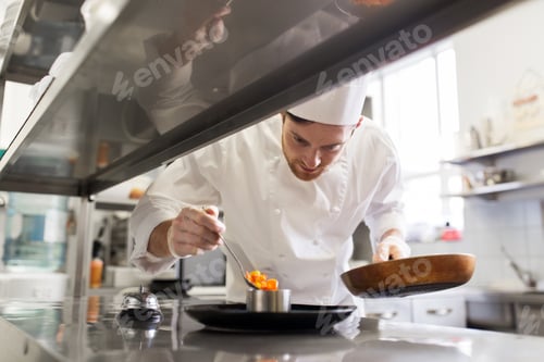 Preview: happy male chef cooking food at restaurant kitchen