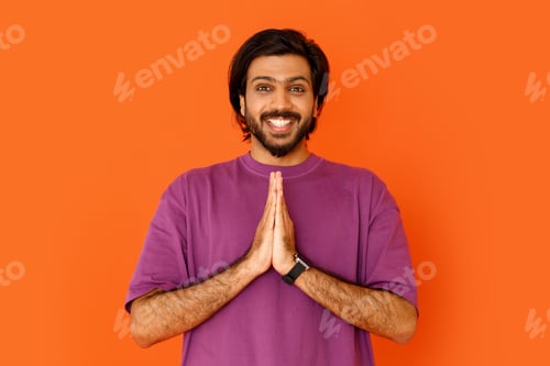 Preview: Happy positive handsome indian guy showing namaste gesture