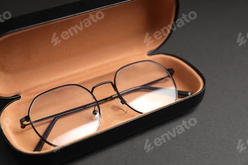 Preview: Case with stylish glasses on gray background, closeup