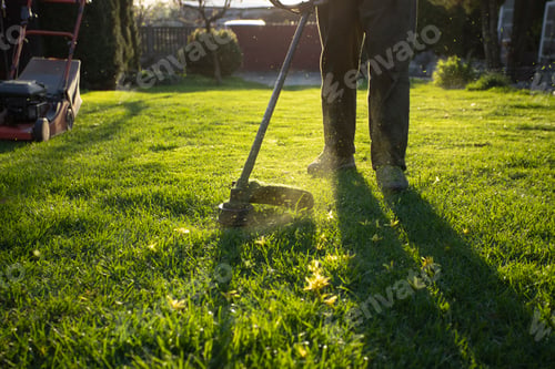 Preview: Garden worker with lawn mover. Garden works in spring.