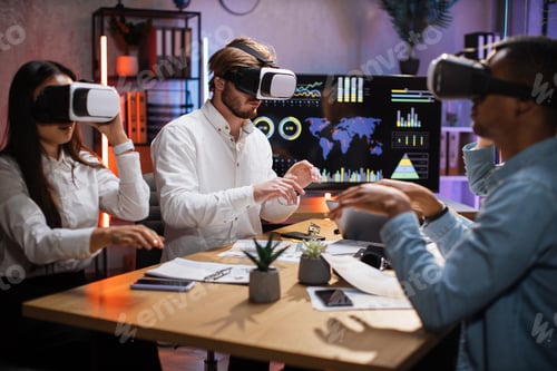 Preview: Group of diverse IT specialists using VR headset at office