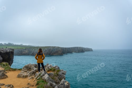 Preview: A young tourist looking at the Jesters of Pria in the town of Llanes. Asturias. Spain