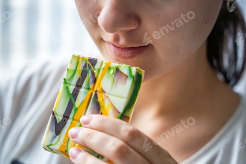 Preview: Woman eating trend Dubai white chocolate with pistachio paste and kataifi dough. Confectionery