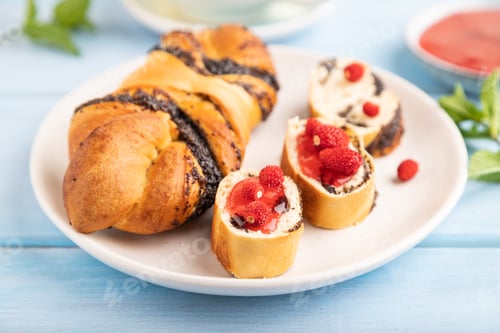 Preview: Sweet bun with strawberry jam on a blue wooden background, side view, selective focus.