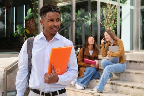 Preview: Confident university student walking and holding a folder with blurred classmates in the background