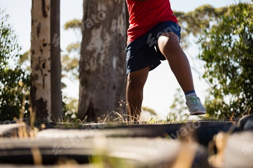 Preview: Boy running over tyres during obstacle course training