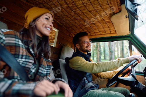 Preview: Young happy couple enjoying in a ride with their travel van.
