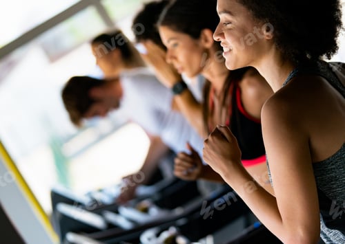 Preview: Fit woman working out in a treadmill at the gym and smiling
