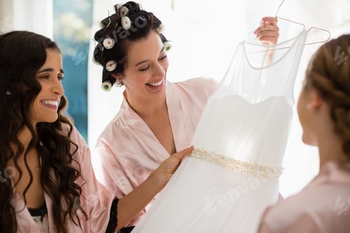 Preview: Smiling women looking at wedding dress