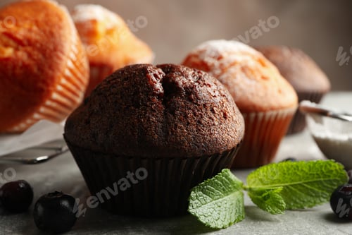 Preview: Composition with delicious muffins on gray background
