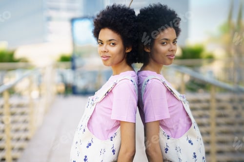 Preview: Glad black woman standing near glass house