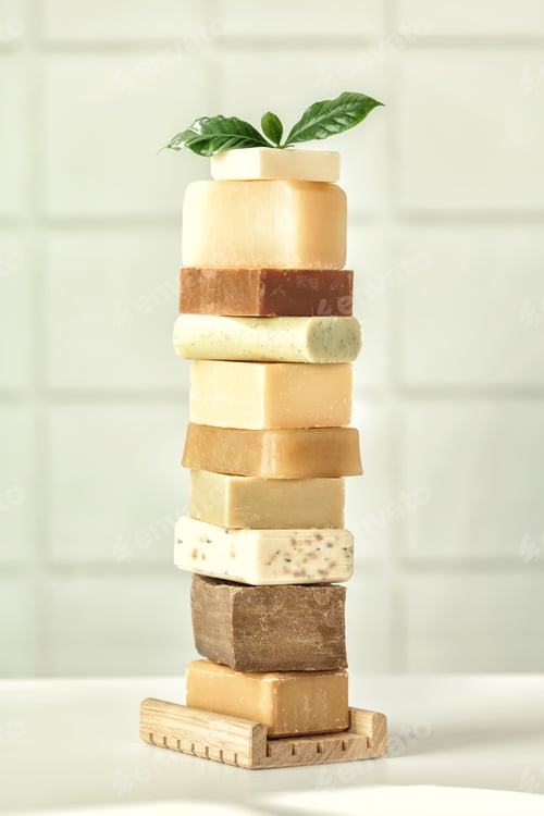 Preview: Stack of assorted natural soap bars on white bathroom countertop