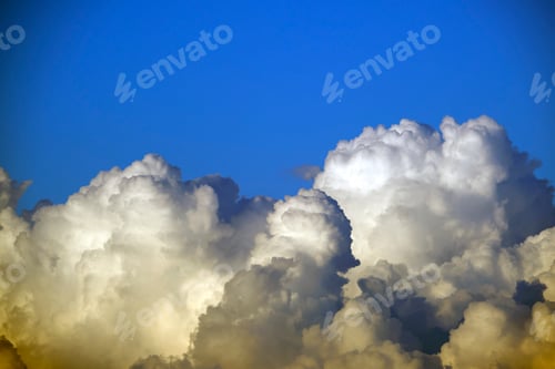 Preview: White fluffy cumulonimbus clouds forming before thunderstorm on summer blue sky.