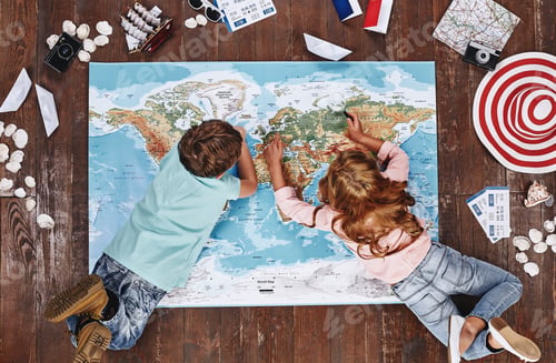 Preview: Where would you like to visit Children looking at world map, while lying on it, near travel items