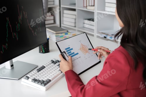 Preview: Close up view of female stockbroker in red clothes works in the office with financial market, analy