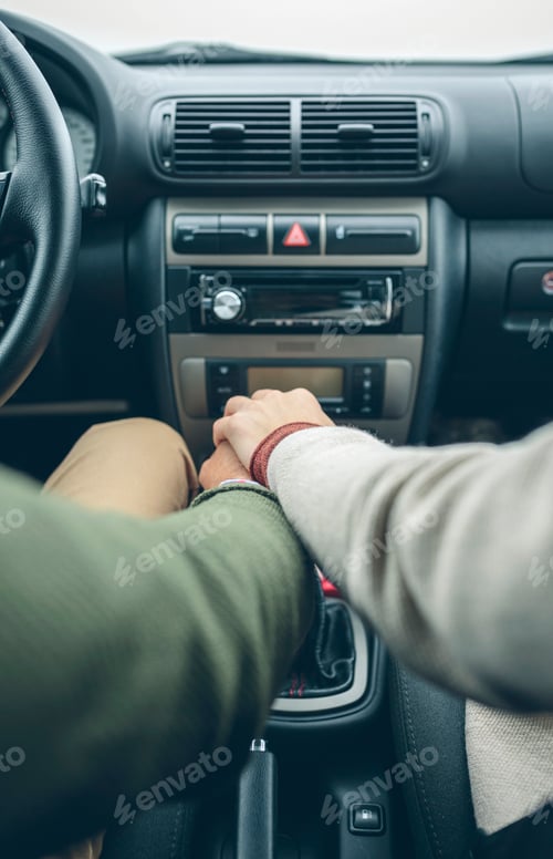 Preview: Woman putting her hand on man's hand using gear shift in car