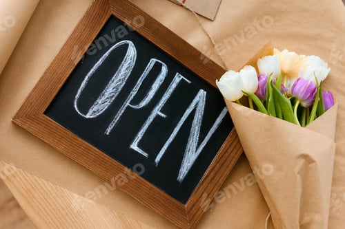 Preview: top view of beautiful bouquet of tulips and open sign on craft paper