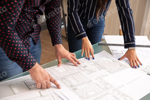 Preview: Close up with the hands of two architects pointing to a project plan
