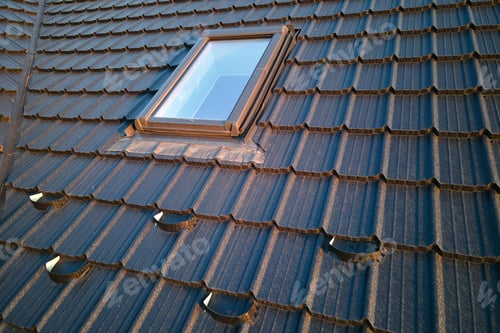 Preview: Closeup of attic window on house roof top covered with ceramic shingles. Tiled covering of building