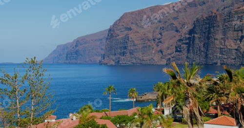 Preview: Canary Islands, Tenerife. Mountain resort town with many hotels, palm trees. Los Gigantes Cliffs