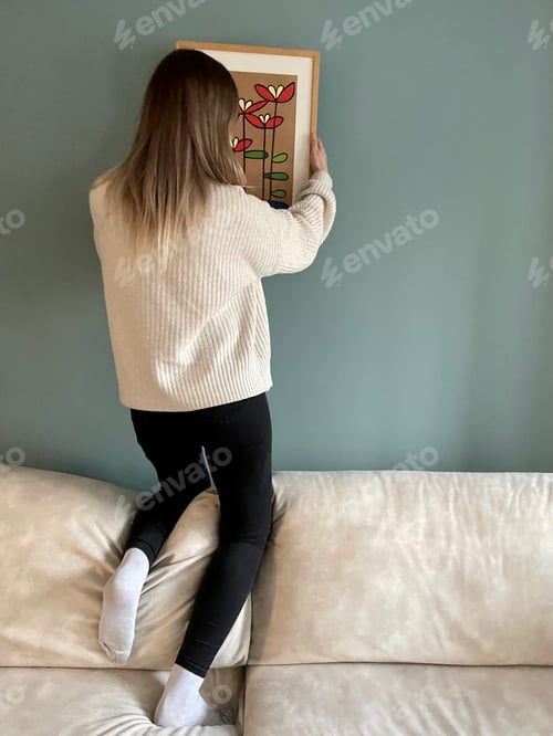 Preview: Woman Hanging Flower Painting in Home Environment