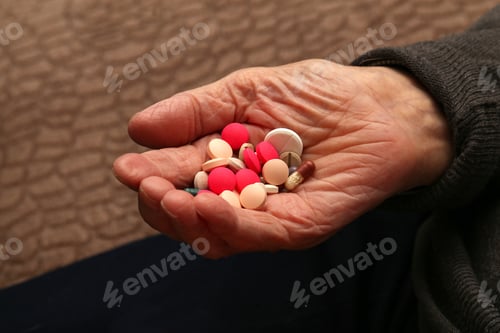 Preview: Closeup shot of an elderly hand holding various pills
