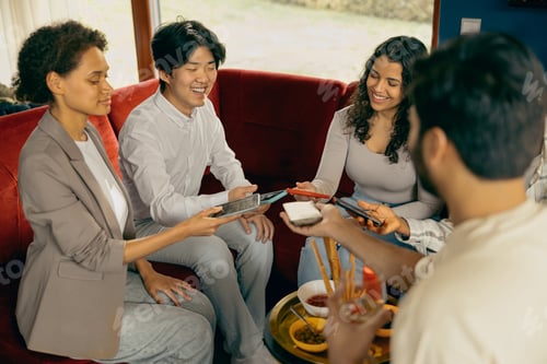 Preview: Happy group of friends sharing each other photos they made on phone on holiday party
