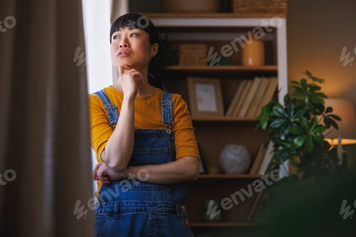 Preview: Woman looking out the window and relaxing at home