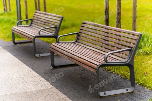 Preview: Sunny park with a well-kept field of grass and benches on pavement